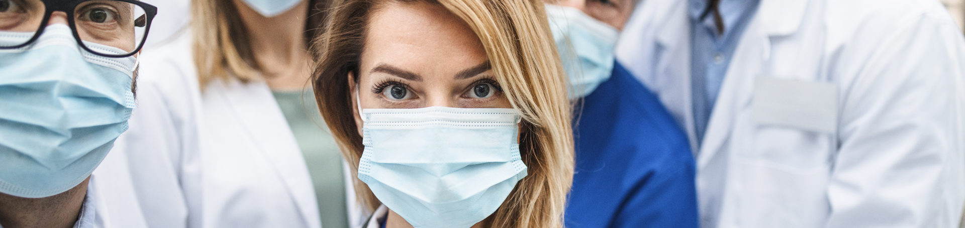 woman in medical mask looking into camera