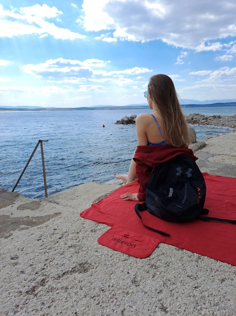 woman sitting at the edge of lake